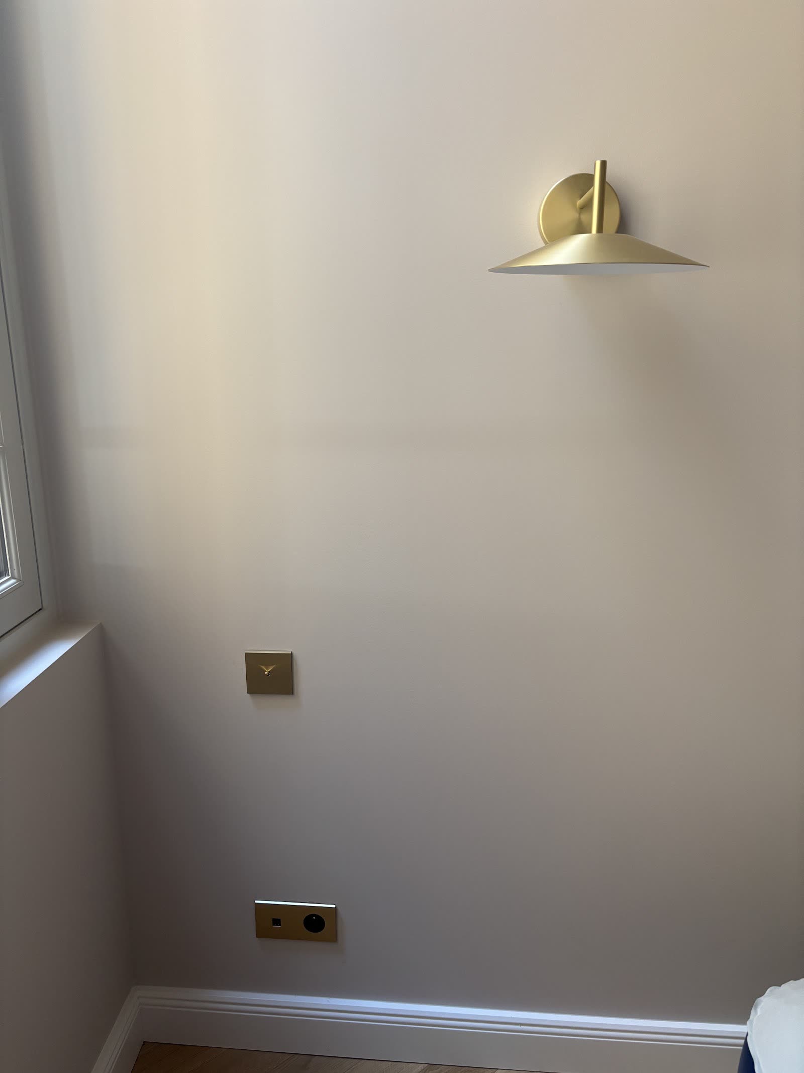 Applique murale et prises électriques installées dans une pièce rénovée