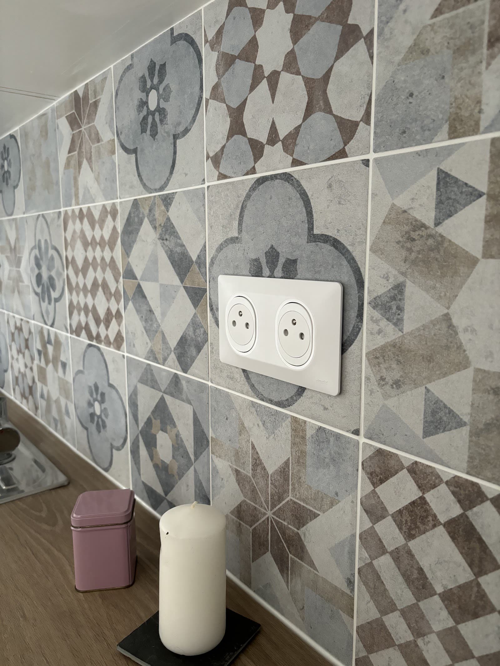 Prise électrique double posée sur une crédence en carreaux décoratifs