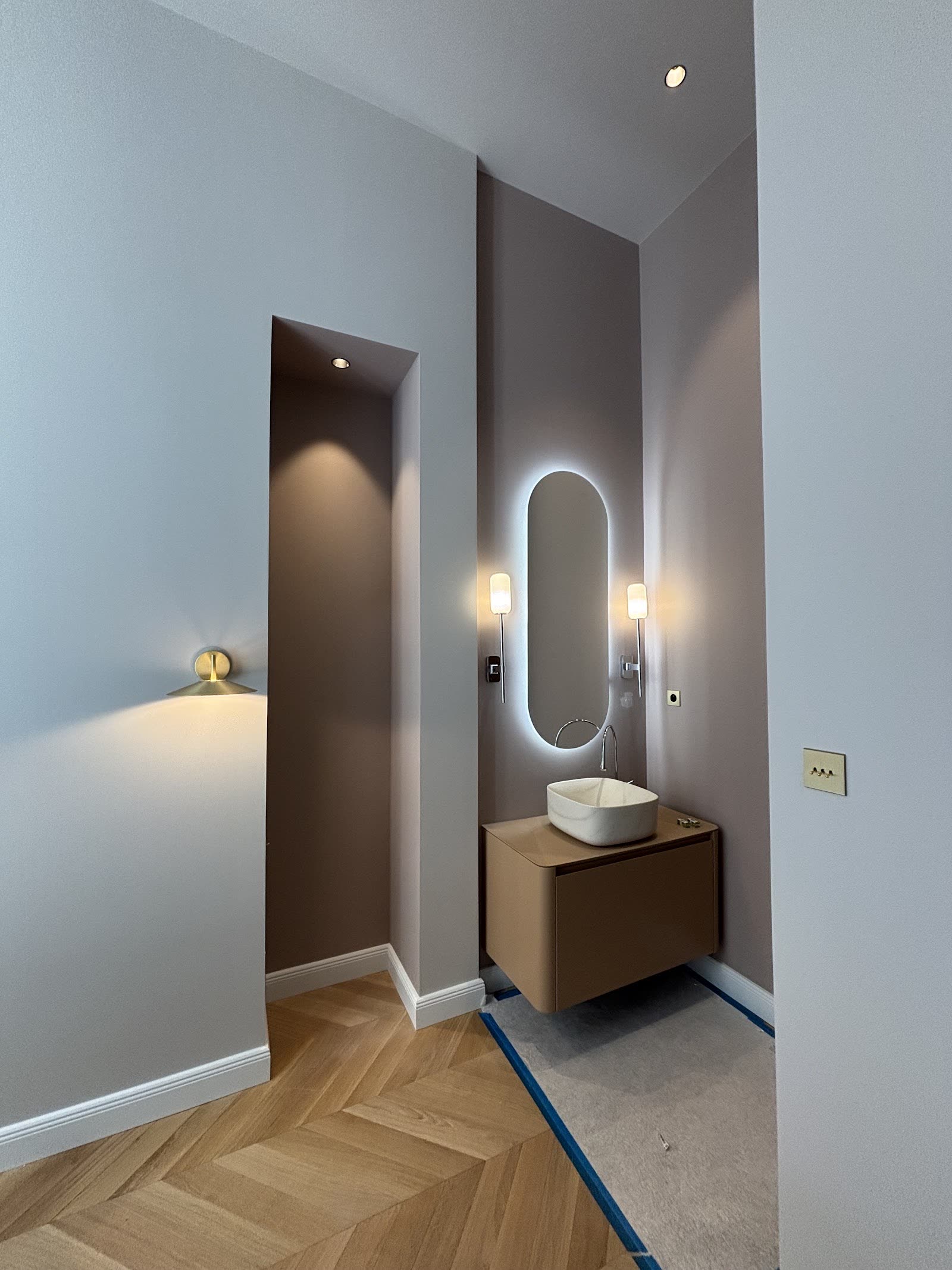 Éclairage mural et miroir lumineux dans un espace de toilette rénové